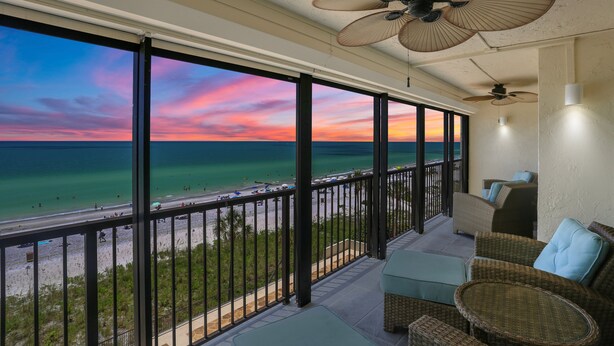 A balcony with a view of the beach and ocean during sunset. - 🌅 Ocean Sands II #606 — Gulf Front Elegance with Sunset Views (Madeira Beach)