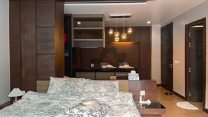 Ein Schlafzimmer mit einem großen Bett, einem Schreibtisch und einer Essecke.