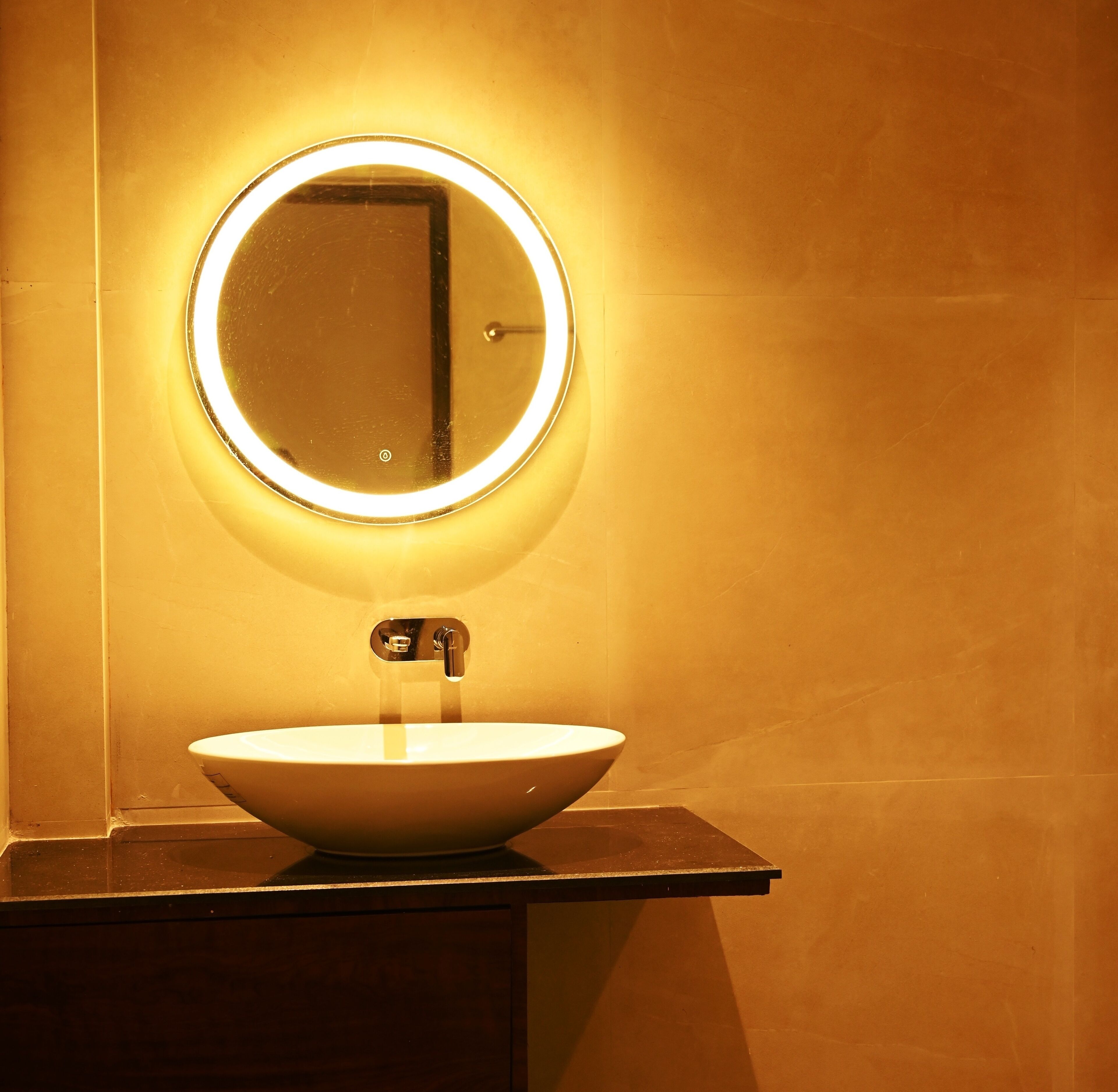 Un baño con un espejo redondo, un lavabo y un grifo.