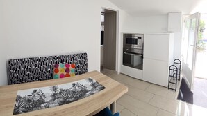 A modern kitchen with white cabinets, a built-in oven, and a microwave.