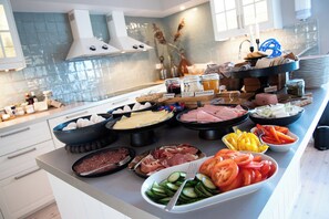 A buffet with various food items including meats, cheeses, and vegetables.