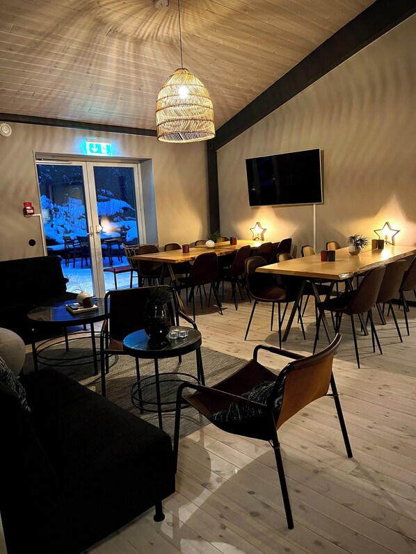 A conference room with a large table, chairs, a television, and a ceiling light.