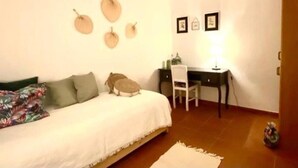 A bedroom with a bed, a desk, and a chair. There are wall decorations and a lamp on the desk. - Charming 5-bed House in Granja (Mourão)