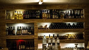 A bar with multiple shelves of bottles and glasses. - Pensiunea Padina Ursului (Fundata)