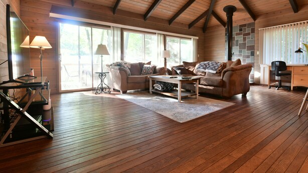 A spacious living room with wooden floors, a high ceiling, and large windows. - Spacious, renovated 3 bedroom home in Traverse City (Traverse City)