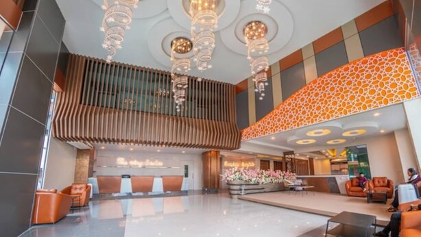 A spacious lobby with a reception desk, seating area, and a decorative ceiling. - The Ring Border (Sadao)