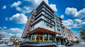 A multi-story hotel with a modern design, featuring a prominent entrance with a sign that reads "The Rising Border." - The Ring Border (Sadao)