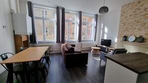 Un salon moderne avec un canapé, une table à manger et un téléviseur.