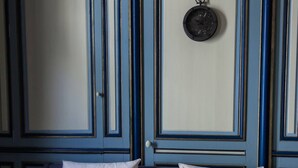 Une pièce comprenant un lit, une horloge murale et des moulures décoratives.