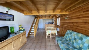 A cozy cabin interior with a wooden staircase, a dining area, and a sofa. - Duplex 4-bedroom apartment, 250m from slopes, parking, sleeps 10 - Les Angles (Les Angles)
