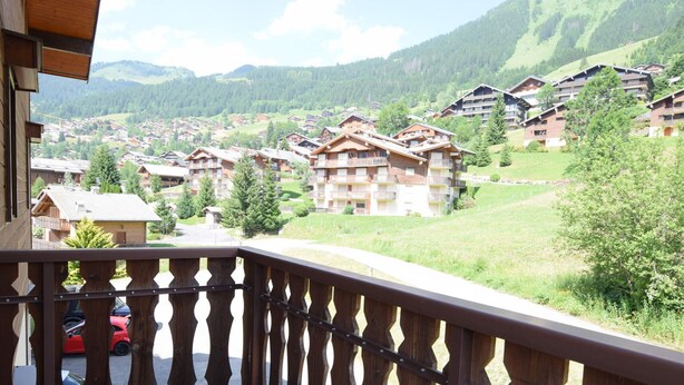 A balcony with a view of a mountain village with chalet-style buildings. - Bright apartment for 6 people with balcony and parking in Châtel (Châtel)