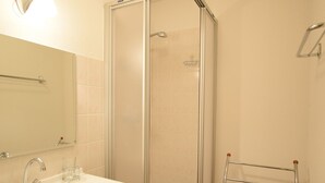 A bathroom with a glass-enclosed shower, a sink with a mirror, and a towel rack. - Bright apartment for 6 people with balcony and parking in Châtel (Châtel)