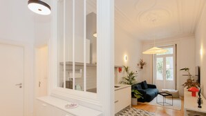 Una cucina moderna con mobili bianchi, una finestra e un piccolo tavolo con un piatto.