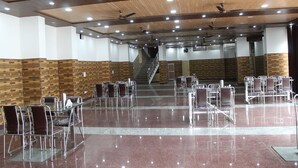 A spacious hall with a polished floor, multiple seating areas, and a staircase leading to an upper level. - Jalal Palace (Almora)
