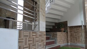 A modern interior with a staircase, patterned walls, and a green carpet. - Jalal Palace (Almora)