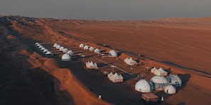 An aerial view of a desert resort with yurts and tents arranged in rows. - Luxury Desert Camp Oman (Bidiya)
