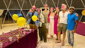 A group of people at a party with a table covered in confetti and balloons. - Luxury Desert Camp Oman (Bidiya)