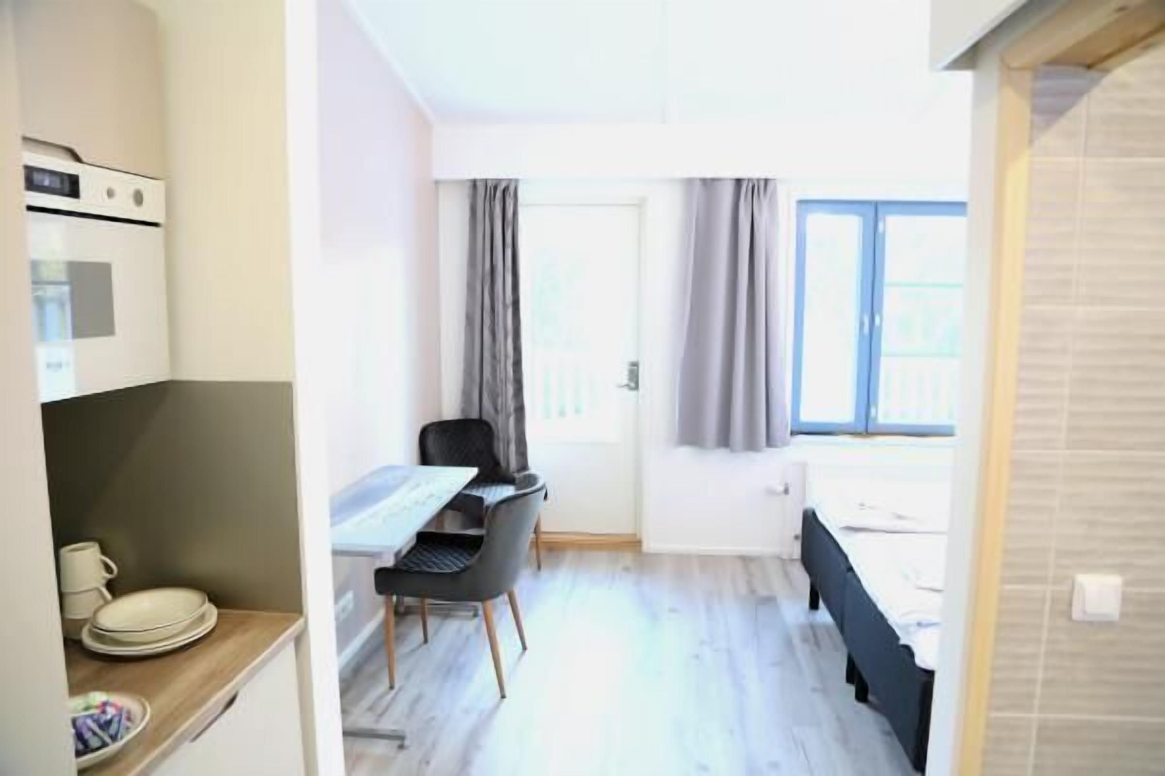 Ein gemütlicher Raum mit Küchenzeile, Essbereich und Bett.