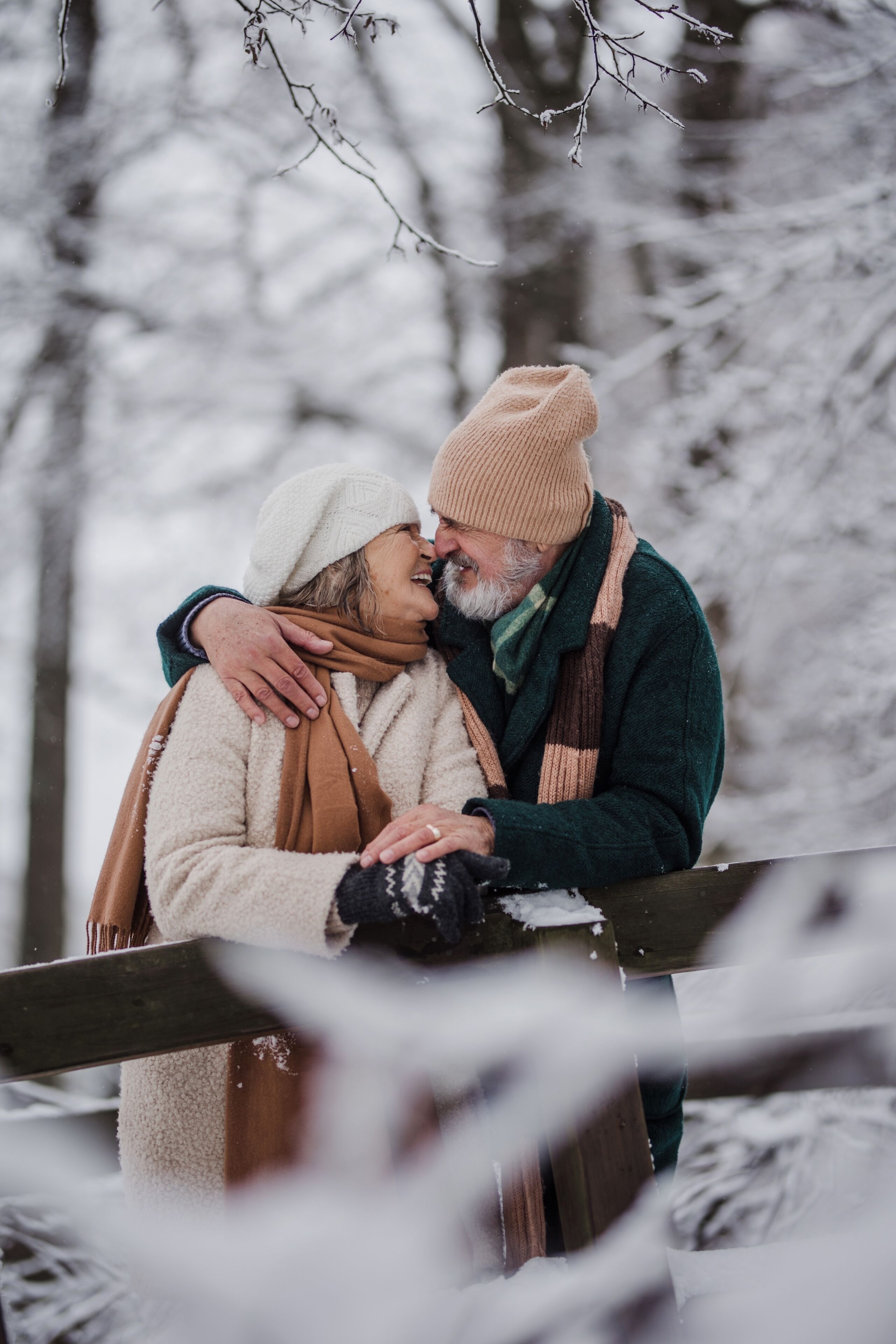 A couple embracing in a snowy outdoor setting.