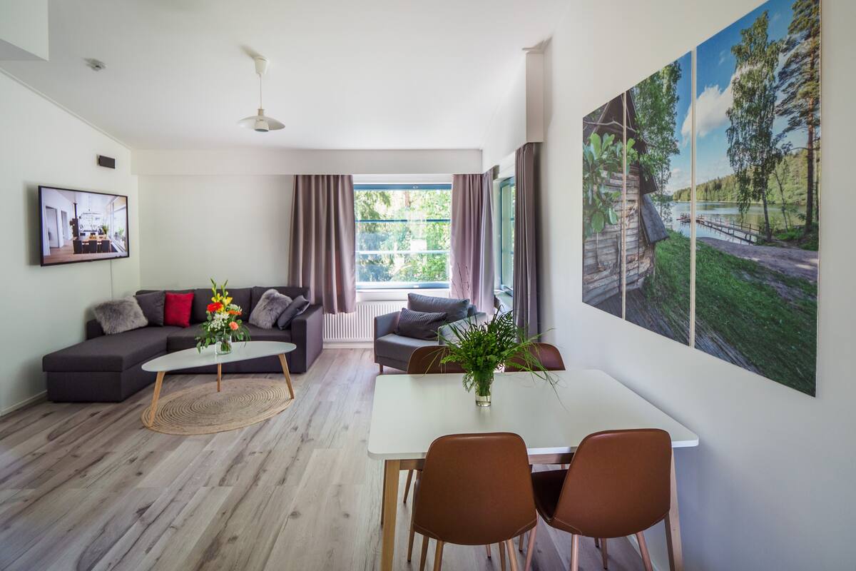 Ett modernt vardagsrum med en soffa, ett soffbord och en matplats.