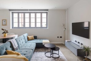 Relax in this stylish living room with a sofa, flat-screen TV, and floor lamp.