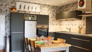 A modern kitchen with a dining area, featuring a refrigerator, oven, and stainless steel appliances. - 200 m from the beach, lovely flat for 4 people (Saint-Gildas-de-Rhuys)