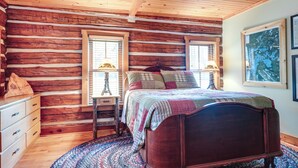 A log cabin-style bedroom with a wooden bed, two bedside tables, and a dresser. - Dog-Friendly Park Falls Cottage w/ 5 Acres & Lake (Park Falls)