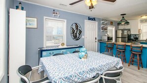 A compact kitchen with a dining area, featuring a ceiling fan, a microwave, and a refrigerator. - The Treasure Chest - 3 BR/2 BA Upper Part of Duplex in the Heart of Surf City (Surf City)