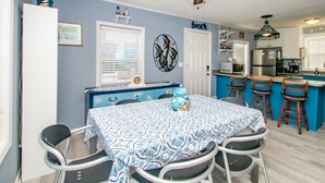 A dining area with a table covered in a patterned tablecloth, surrounded by chairs. - The Treasure Chest - 3 BR/2 BA Upper Part of Duplex in the Heart of Surf City (Surf City)
