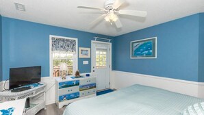 A bedroom with a bed, a dresser, a television, and a ceiling fan. - The Treasure Chest - 3 BR/2 BA Upper Part of Duplex in the Heart of Surf City (Surf City)
