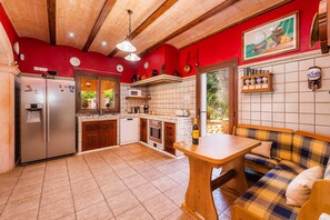 Una cocina con refrigerador, microondas, estufa y armarios de madera.