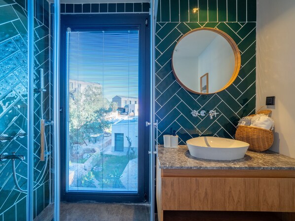 A bathroom with a large window, a round mirror, and a sink. - Notos Club (Kas)