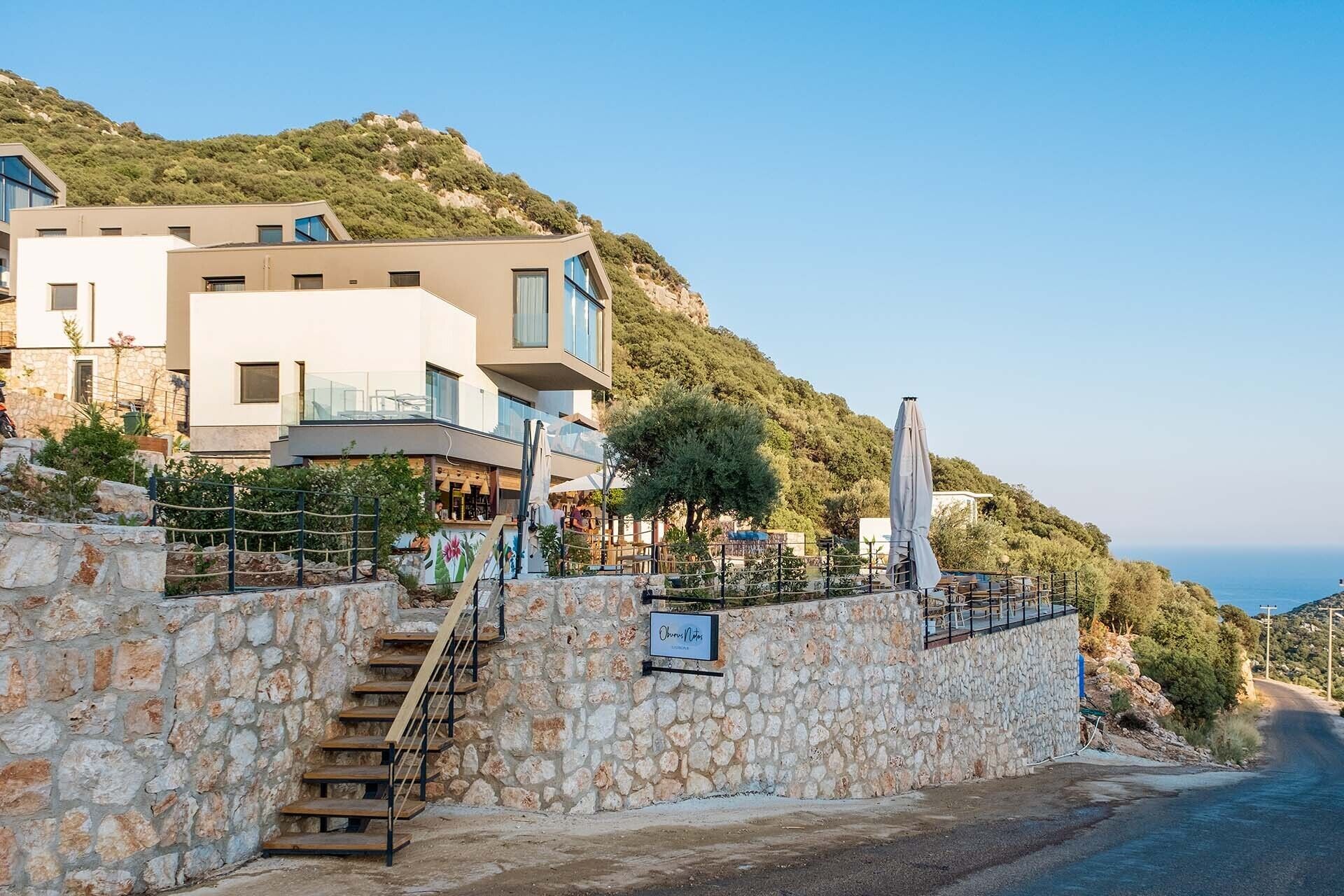 A modern building with a stone staircase leading to a restaurant.