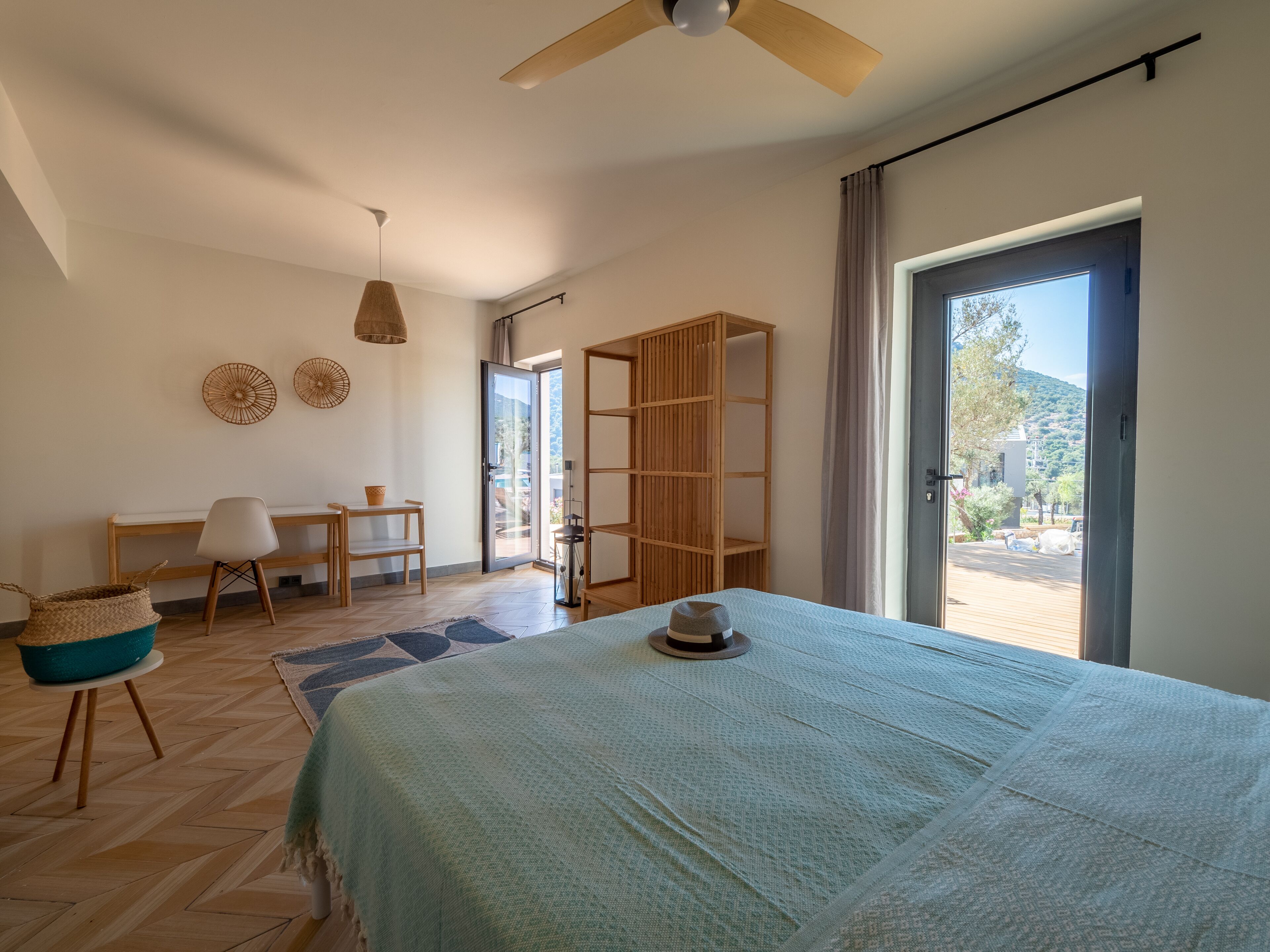 Une chambre à coucher comprenant un lit, un bureau, une chaise, une armoire et donnant sur l ’extérieur.