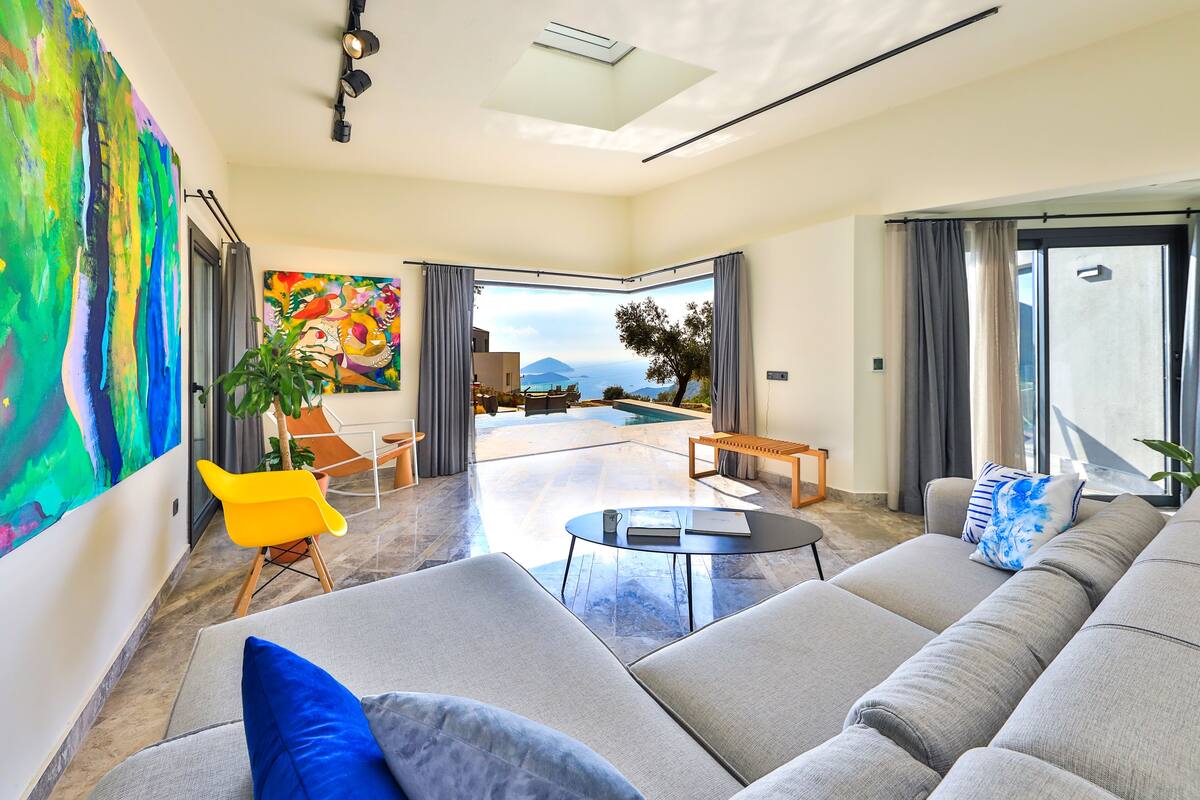 A modern living room with a large sofa, a coffee table, and a vibrant abstract painting.