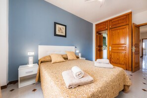 A bedroom with a bed, nightstands, a framed picture, and a wooden door.