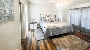 Una camera da letto con un letto, un comodino e una ventola a soffitto.