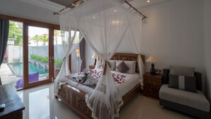 A bedroom with a canopy bed, a small bedside table, a nightstand, and a sofa. - Royani 1-Bedroom Private Pool Villa (Gianyar)