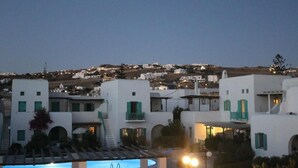 A coastal town with white buildings, green shutters, and a pool area. - Glamorous 2BR Villa in Ornos w Sea View (Mykonos)
