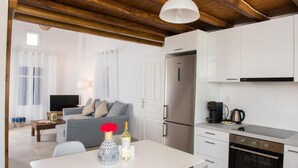 A modern kitchen with white cabinets, a stainless steel refrigerator, and a built-in oven. - Glamorous 2BR Villa in Ornos w Sea View (Mykonos)