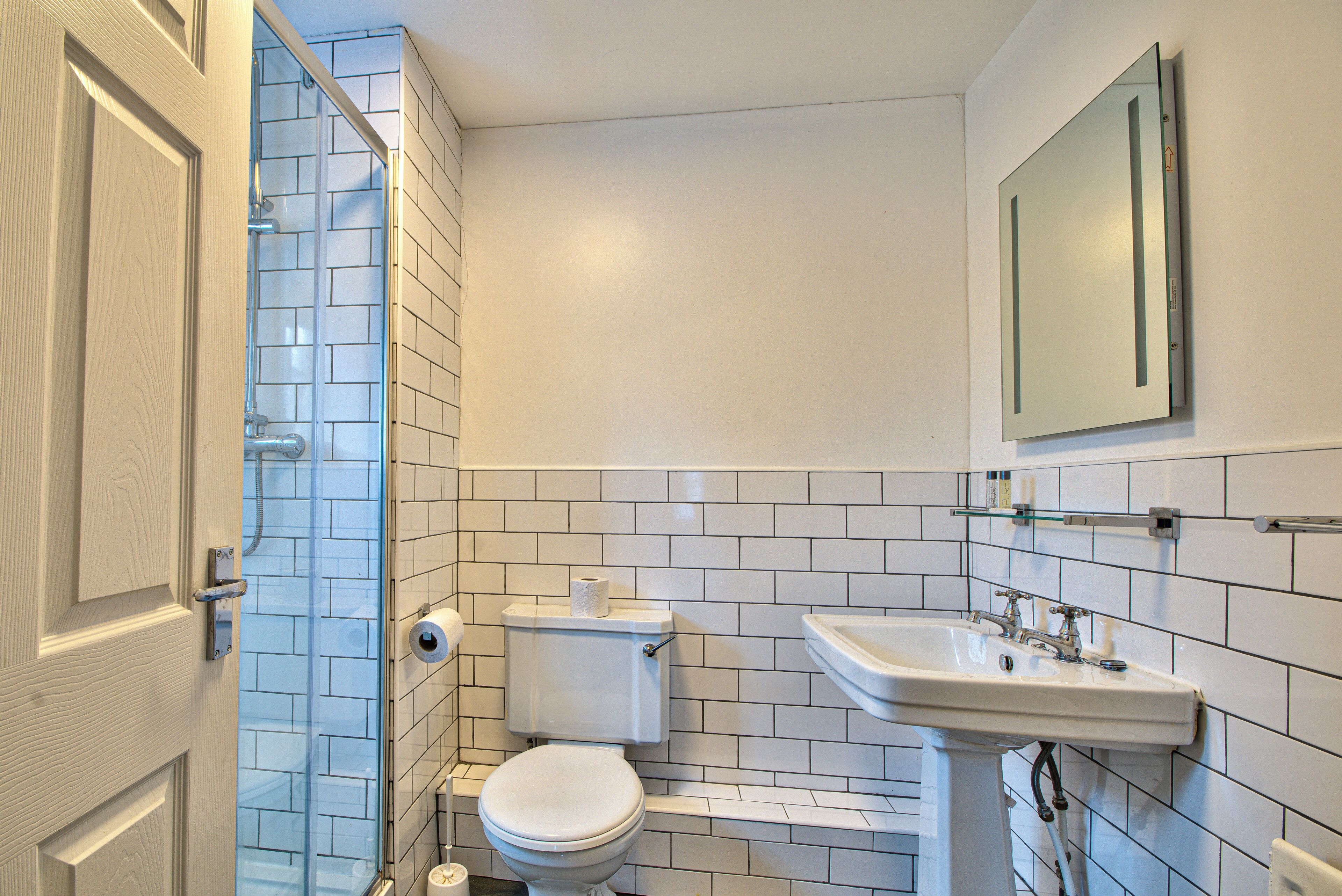 Un baño con inodoro, lavamanos y ducha.