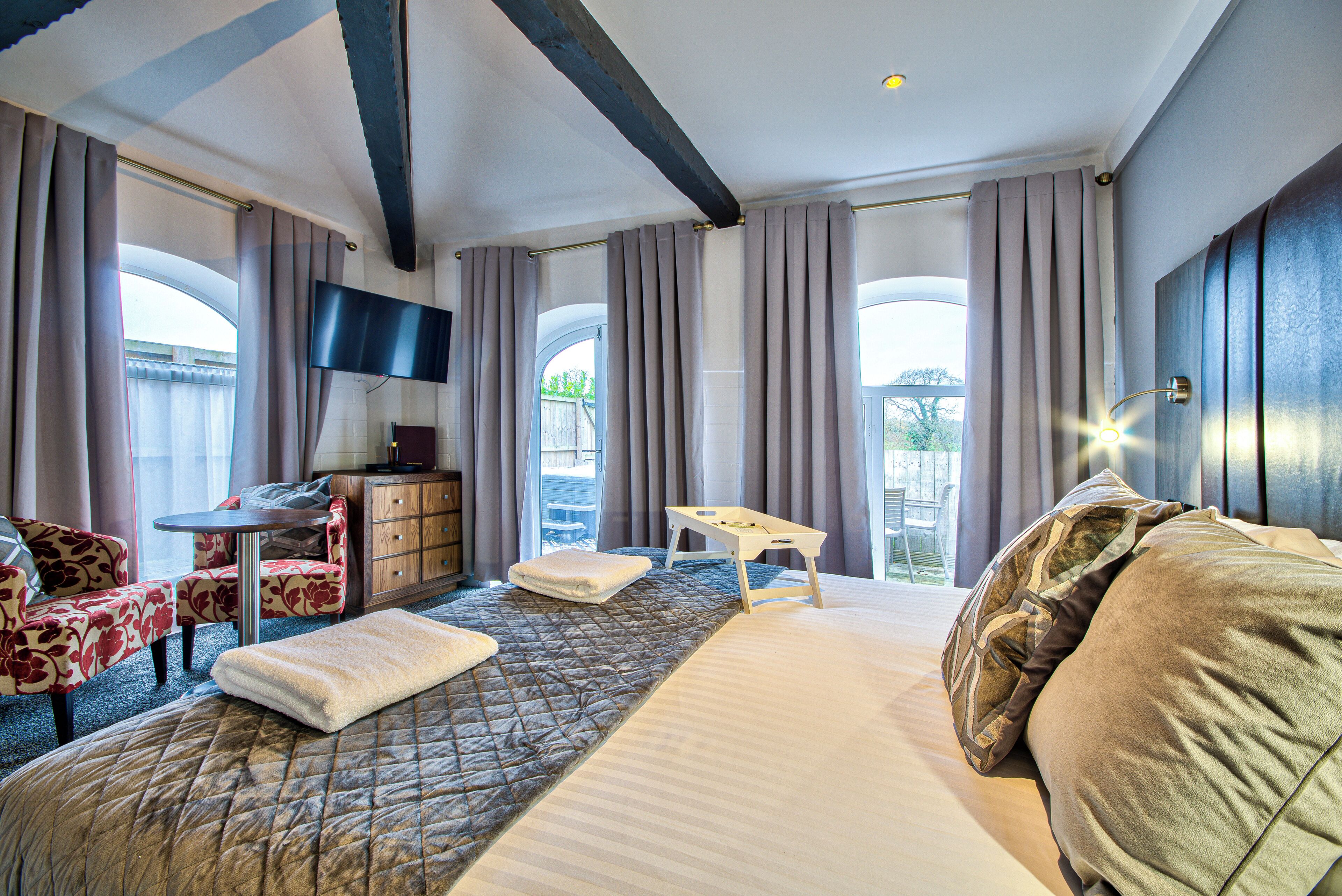 Una camera d'albergo con un letto, una scrivania, una televisione e vista sull'esterno.