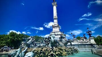 A fountain with a central column and statues of horses and a figure on top.