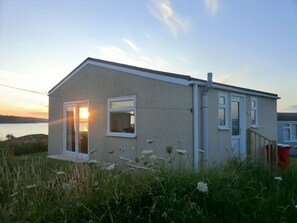 A single-story building with a flat roof, a sliding glass door, and a small porch area. - B44 Sea Urchin, Riviere Towans (Hayle)