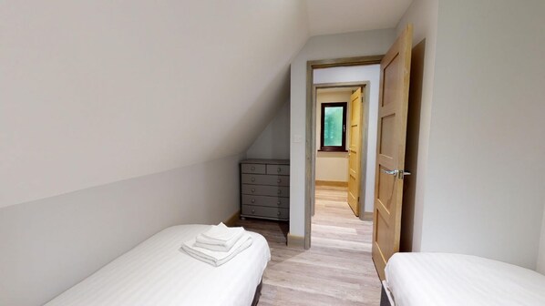 Simple, functional living space with a single bed and wardrobe.