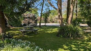 Un espace pique-nique équipé de bancs, entouré d’une végétation luxuriante et d’arbres.