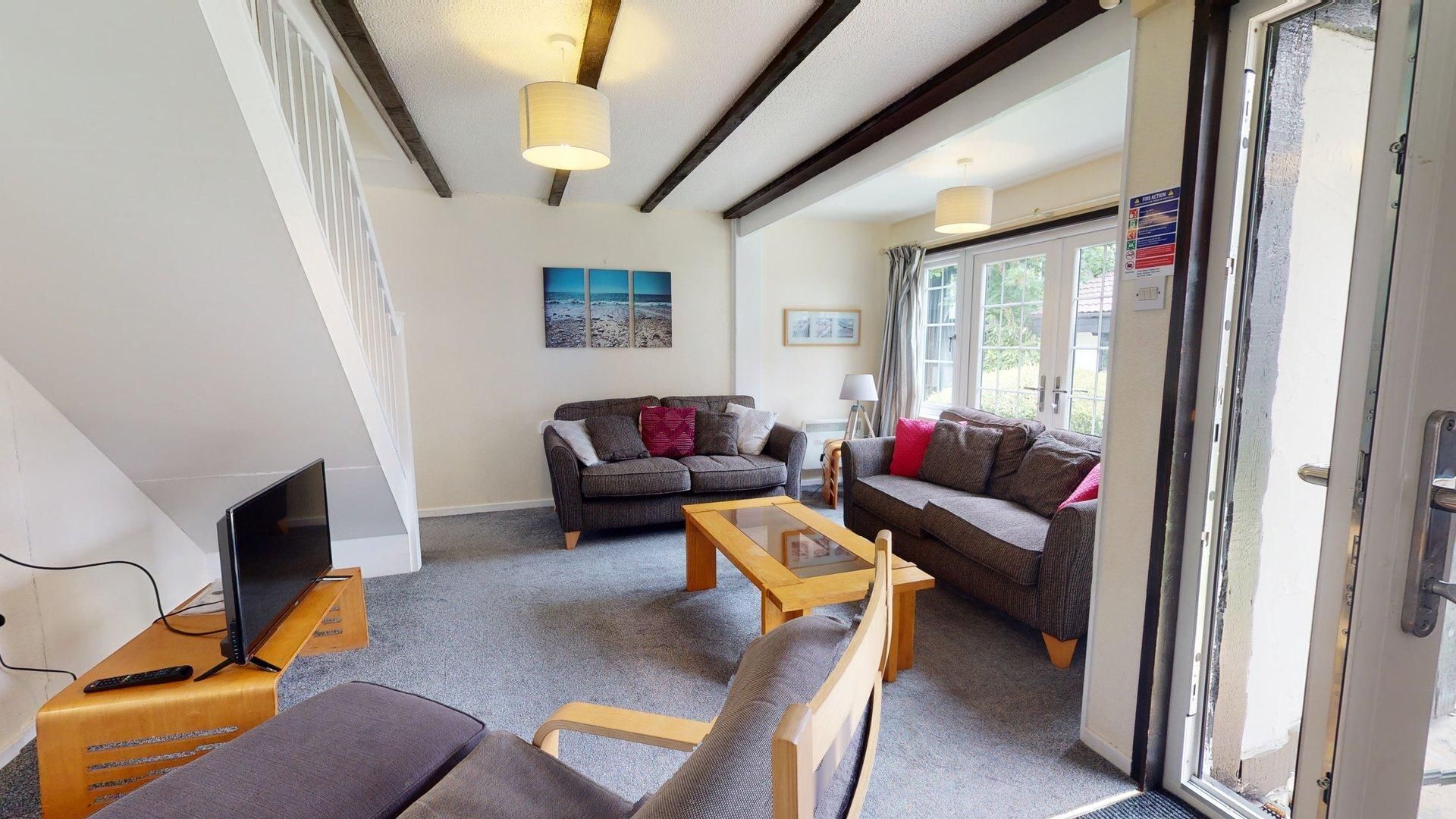A living room with a sofa, a coffee table, and a TV.