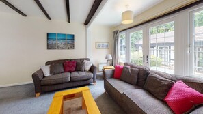 Een woonkamer met een bank, een salontafel en een schilderij aan de muur.