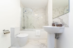 A bathroom with a toilet, sink, and shower. - Somerset Court Apartments (London)