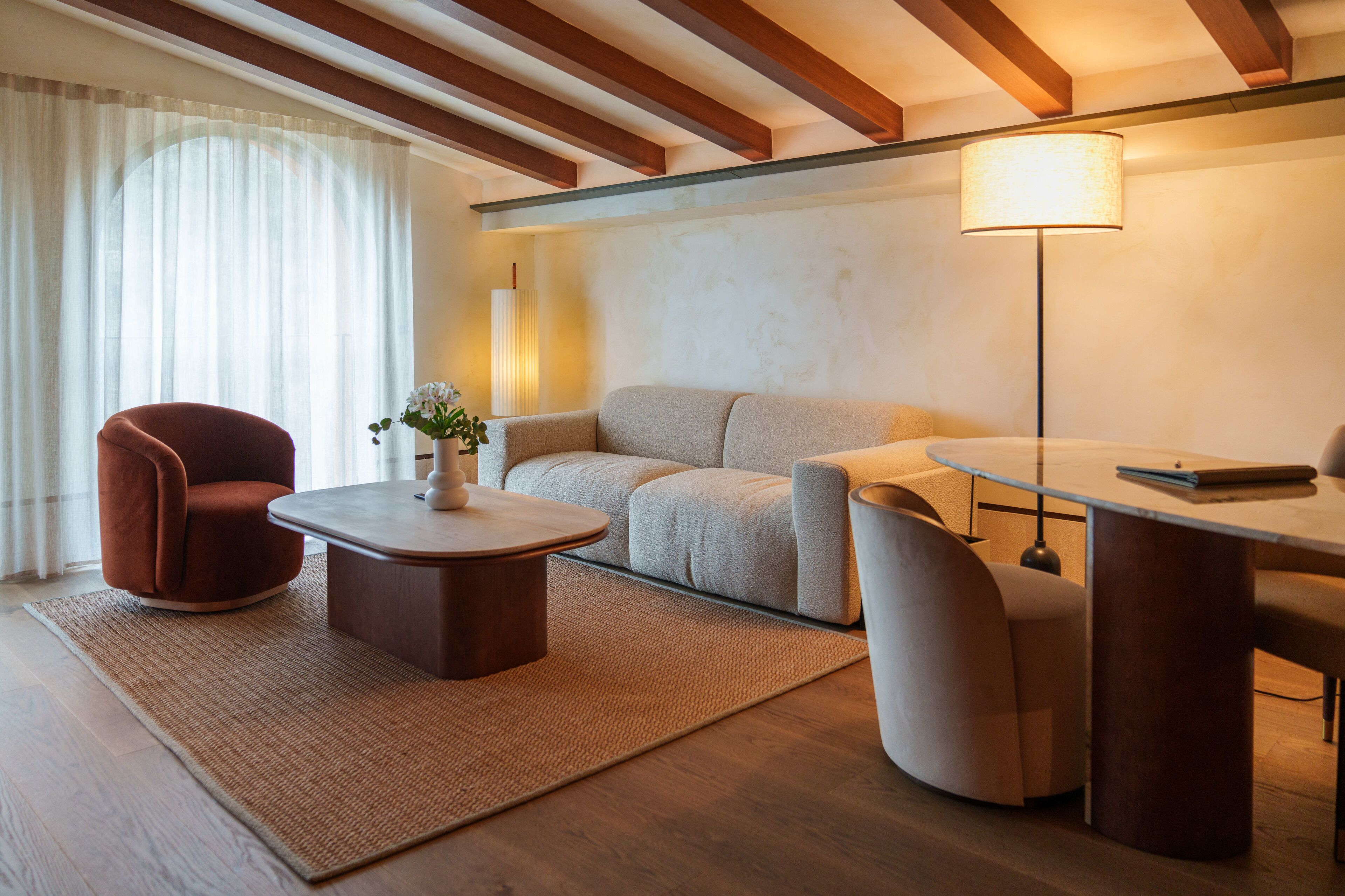 Un salon moderne comprenant un canapé, des fauteuils, une table basse et une table à manger.